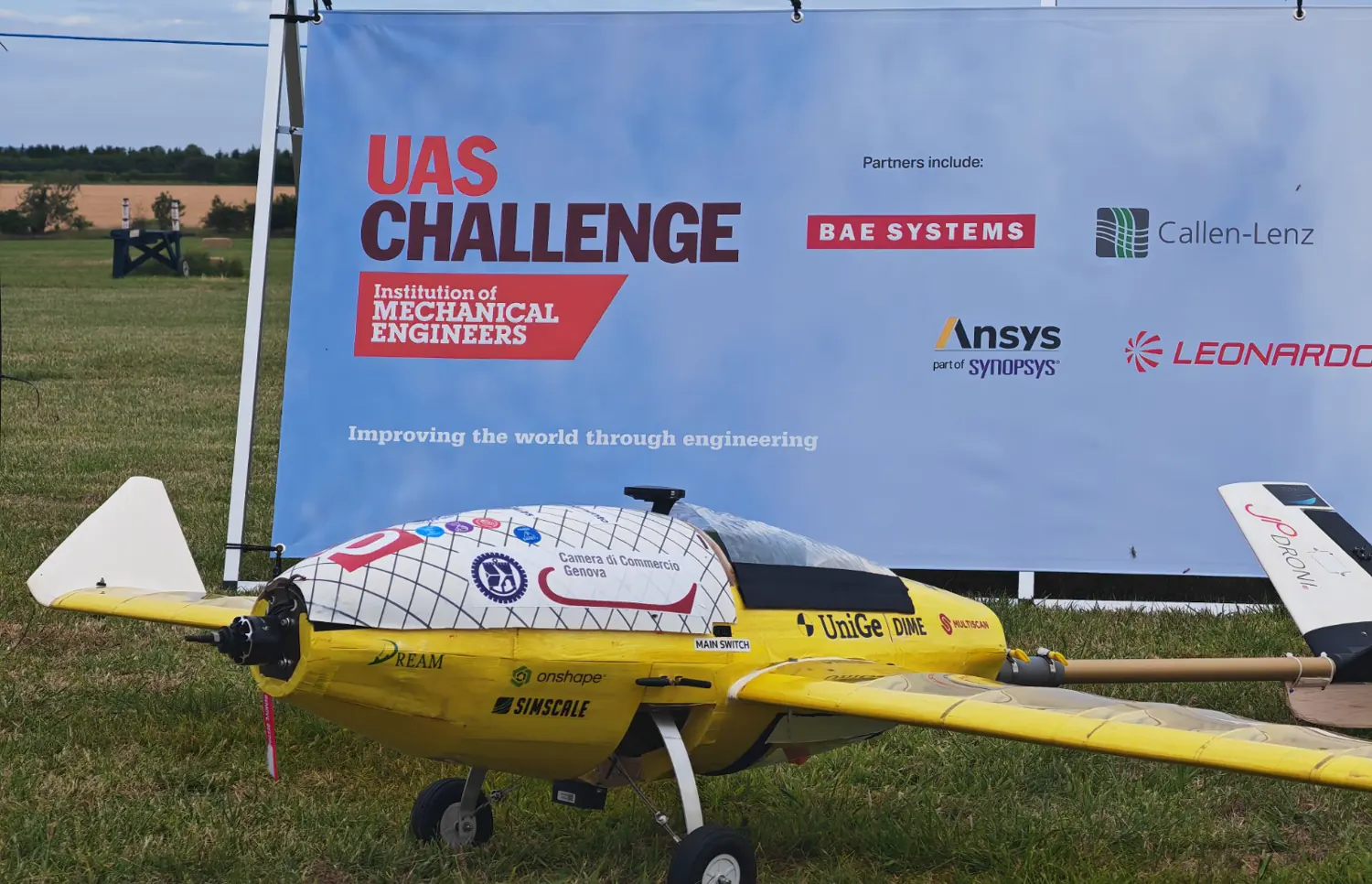 El mismo velículo en tierra delante de la lona de la UAS Challenge, con las marcas de BAE Systems, Ansys y Leonardo.