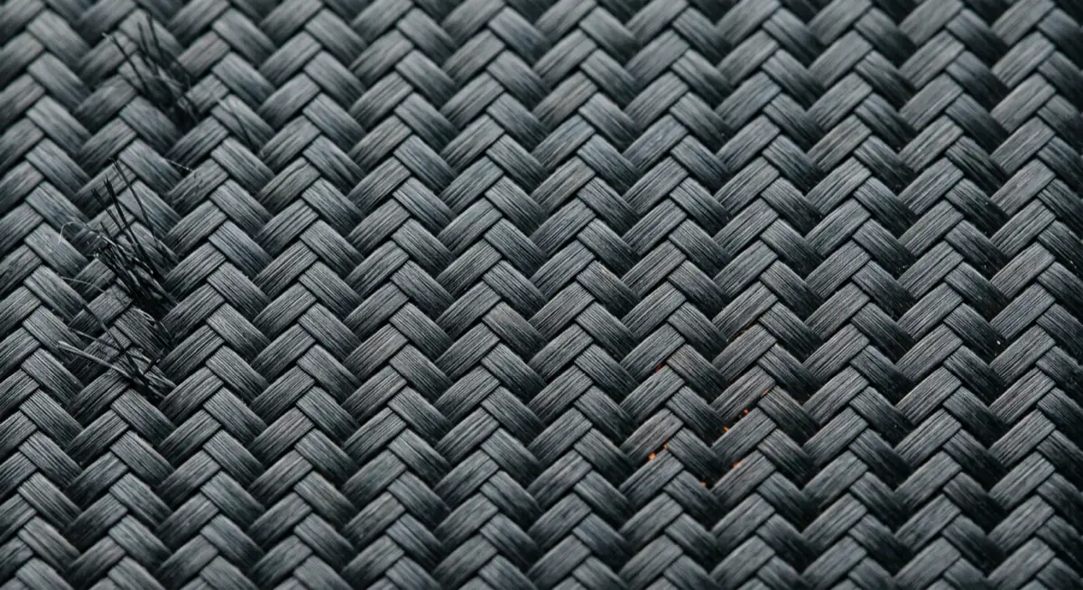 Detalle de cerca de un laminado de fibra de carbono de trama entrelazada.